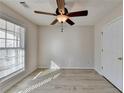Cozy bedroom with light wood-look floors, ceiling fan, and a bright window at 609 Grand Ashbury Ln, Buford, GA 30518