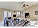 Inviting living room with a fireplace, large windows, and a comfortable leather sofa at 609 Grand Ashbury Ln, Buford, GA 30518