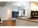 Modern dining area with dark accent wall, light fixture, and hardwood floors adjacent to the kitchen at 154 Carmen Ln, Dallas, GA 30157