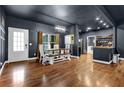 Open-concept dining room with dark walls, hardwood floors, and a farmhouse-style dining table at 154 Carmen Ln, Dallas, GA 30157