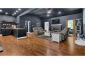 Open-concept living space with dark walls, wood floors, a fireplace, and a breakfast bar area at 154 Carmen Ln, Dallas, GA 30157
