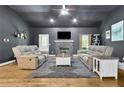 Cozy living room with dark grey walls, wood floors, stone fireplace, and comfortable seating at 154 Carmen Ln, Dallas, GA 30157