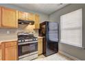 Efficient kitchen features wooden cabinets, stainless steel stove, and black refrigerator, maximizing space at 3216 Panthers Trce, Decatur, GA 30034