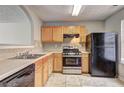Kitchen boasts wooden cabinets, black appliances and a gas range oven at 3216 Panthers Trce, Decatur, GA 30034