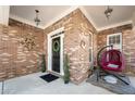 Inviting covered front porch with brick accents, hanging lights, and cozy seating area at 5015 Scuppernong Ct, Austell, GA 30106