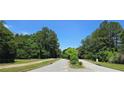 Quiet neighborhood street lined with mature trees and manicured lawns in a residential area at 7491 Hilltop Way, Atlanta, GA 30349