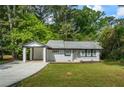 Charming single-story home boasts a covered parking area and a lush green lawn at 2223 Columbia Dr, Decatur, GA 30032