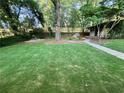 Lush green backyard with mature trees and a charming shed at the end of a paved pathway at 3133 Rebecca St, Covington, GA 30014