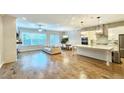 Open-concept living room and kitchen with hardwood floors and modern light fixtures at 2128 Sonoma Se Dr, Smyrna, GA 30080