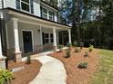 Inviting front porch with white columns, brick accents, and fresh landscaping at 19 Loth Wages (Lot 19) Rd, Dacula, GA 30019