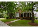 Charming two-story brick home with a welcoming front porch and beautifully landscaped front yard at 2174 Basque Se Dr, Smyrna, GA 30080