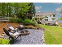 Outdoor seating area with a fire pit for relaxed entertaining and a lush green lawn at 5045 Huntwood Way, Roswell, GA 30075