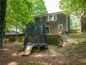 The backyard offers a trampoline and slide plus brickwork, perfect for Gathering fun and outdoor enjoyment at 555 Creekwood Xing, Roswell, GA 30076