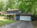 Charming two-story home with a welcoming front porch and well-manicured lawn provides great curb appeal at 555 Creekwood Xing, Roswell, GA 30076