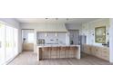 Bright kitchen features a large island with seating, modern appliances, and pendant lighting at 5753 Brendlynn Dr, Suwanee, GA 30024