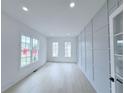 Bright living room with decorative paneled wall and light hardwood flooring at 5753 Brendlynn Dr, Suwanee, GA 30024