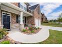 Inviting front porch with stone accents, black door, and neat landscaping at 3236 Papyrus Palm Rd, Loganville, GA 30052