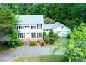 Traditional two-story home with a lush front lawn, mature trees, and a brick driveway leading to an attached garage at 3605 Sewell Mill Rd, Marietta, GA 30062