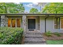 The home's entrance boasts stone pillars, an ornate front door, and stone steps leading up to the entryway at 170 Mark Nw Trl, Sandy Springs, GA 30328
