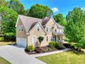 Charming home featuring a well-maintained lawn, mature trees, and a convenient driveway leading to an attached garage at 1615 Mount Mckinley Dr, Grayson, GA 30017