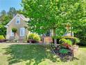 Beautiful residence showcasing a lush green lawn, colorful flower beds, and a welcoming stone staircase to the entrance at 1615 Mount Mckinley Dr, Grayson, GA 30017