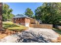 View of the back of the house with a wooden fence, patio, and driveway at 1661 Barrett Nw Dr, Atlanta, GA 30318