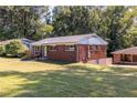 An appealing side view of a brick home on a spacious lot with mature trees at 1661 Barrett Nw Dr, Atlanta, GA 30318