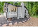 Charming home featuring a cozy covered porch, a brick chimney, and a landscaped yard at 353 Old Rosser Rd, Stone Mountain, GA 30087