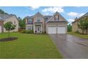 Beautiful two-story home featuring a two-car garage and a lush green lawn at 5130 Hopewell Manor Dr, Cumming, GA 30028