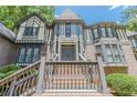 Close-up of the home's impressive front entrance with stairs, custom brickwork, and Tudor details at 5460 Lichenhearth Ct, Stone Mountain, GA 30087