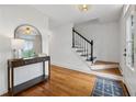 Bright entryway featuring hardwood floors, a staircase with black handrail, and a console table with mirror at 1275 Mayfield Rd, Milton, GA 30009