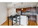 Modern kitchen featuring stainless steel appliances, dark cabinets, and a stylish breakfast bar with seating at 950 W Peachtree Nw St # 904, Atlanta, GA 30309