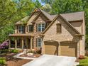 Charming two-story home boasts a stone and brick facade, two car garage and a beautifully landscaped front yard at 121 Brendylynn Trce, Woodstock, GA 30188