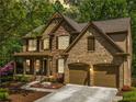 Charming two-story home boasts a stone and brick facade, two car garage and a beautifully landscaped front yard at 121 Brendylynn Trce, Woodstock, GA 30188