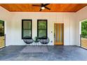Cozy front porch featuring a ceiling fan, slate flooring, modern furniture, and a view of the wooded surroundings at 2438 2Nd Nw St, Atlanta, GA 30318