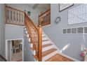 Interior view of staircase with wooden banisters, white risers, and a glimpse of the laundry room at 324 Madeline Way, Temple, GA 30179
