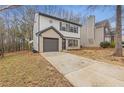 Two-story home with an attached garage, long driveway, and mature landscaping at 7074 Ravenwood Ln, Lithonia, GA 30038