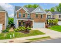 Two-story brick home with a two-car garage and a charming front porch with manicured landscaping at 123 Woodford Ln, Canton, GA 30115