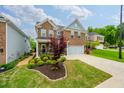 A lush green lawn and beautiful landscaping accent this two-story brick home with a two-car garage at 123 Woodford Ln, Canton, GA 30115