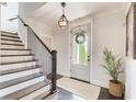 Inviting foyer features hardwood floors, staircase, and a glass front door with a decorative wreath at 164 Inwood Walk, Woodstock, GA 30188
