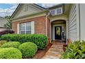 Inviting brick home with a covered front entry, complemented by manicured bushes and stone pathway at 4485 Cadmium Dr, Cumming, GA 30040