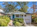 Charming brick home with a well-manicured lawn, inviting entrance, and attached garage at 490 E Pharr Rd, Decatur, GA 30030