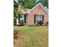 Charming brick home featuring black shutters, manicured landscaping, and a well-maintained lawn at 1150 Hillary Ln, Lawrenceville, GA 30043