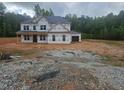 Unfinished two-story home with visible framework and a lush green backdrop showcases potential at 3301 Lions Ruby Ln, Atlanta, GA 30349