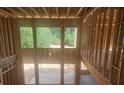 View of the house's interior featuring wood framing and a high-ceilinged foyer with window views of wooded lot at 3301 Lions Ruby Ln, Atlanta, GA 30349