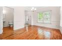 Open dining room featuring hardwood floors, natural light, classic molding and entry to half bathroom at 557 Lawton Sw St, Atlanta, GA 30310