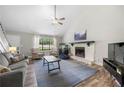 Cozy living room featuring a stone fireplace, vaulted ceilings, and ample natural light at 4934 Woodstream Nw Ln, Acworth, GA 30102