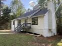 Charming home featuring fresh white siding, dark roof, blue front door, and well-maintained landscaping at 600 Mary Erna Dr, Fairburn, GA 30213