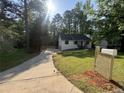 Traditional single-Gathering home featuring lush front lawn, driveway, mature trees, and a wooden mailbox at 600 Mary Erna Dr, Fairburn, GA 30213