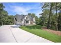 Elegant two-story home featuring a spacious driveway and lush green lawn surrounded by trees at 6861 Ga Hwy 5, Douglasville, GA 30135
